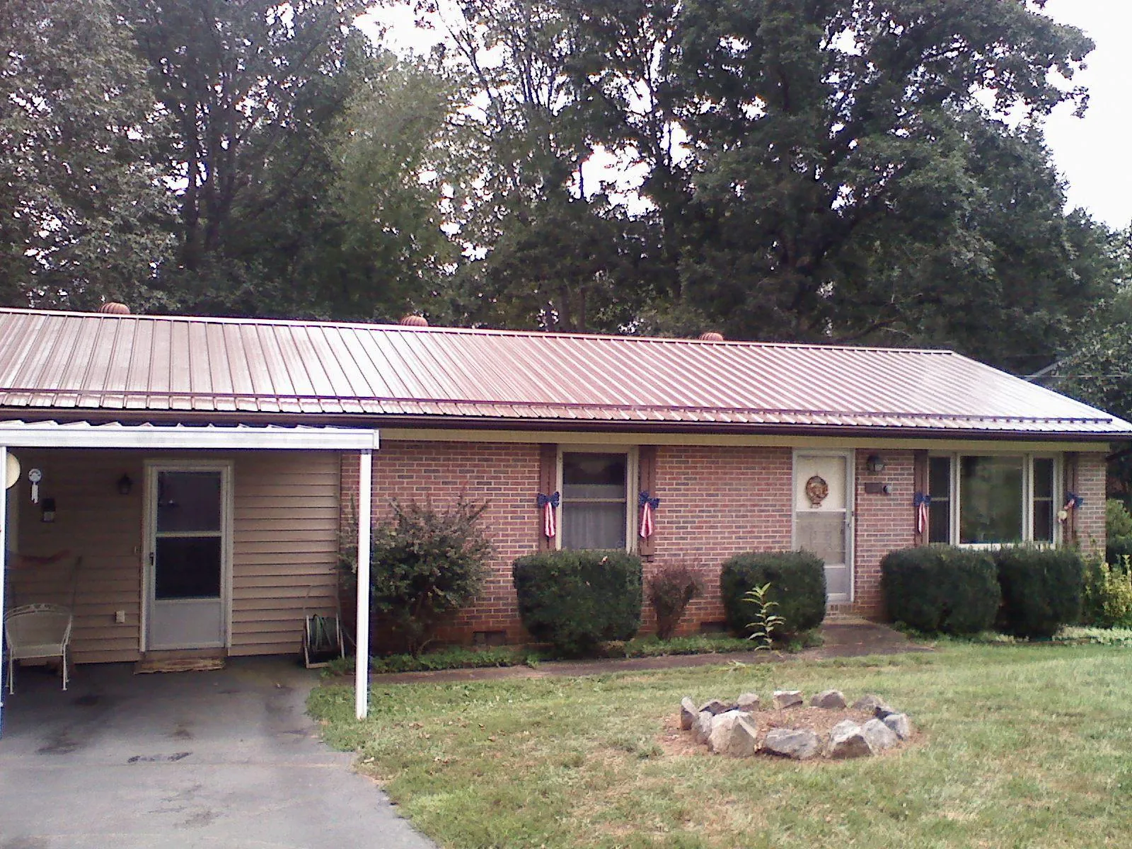 Bronze metal roof and carport on a brick ranch home — Roof Repair work by our crew in Beaver